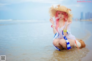 A woman in a straw hat standing in the water.