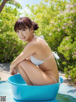 A naked asian woman sitting on a bed with a flower in her hair.