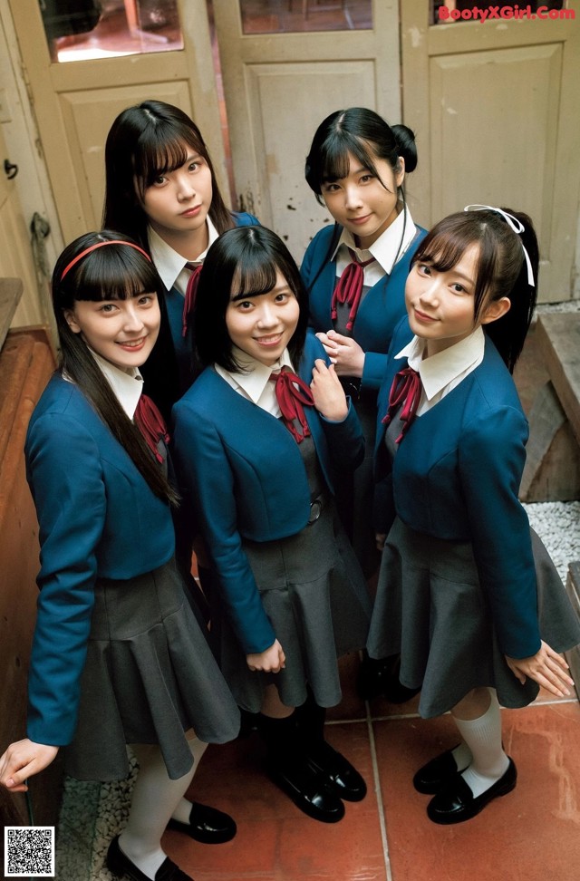 A group of young women in school uniforms posing for a picture.