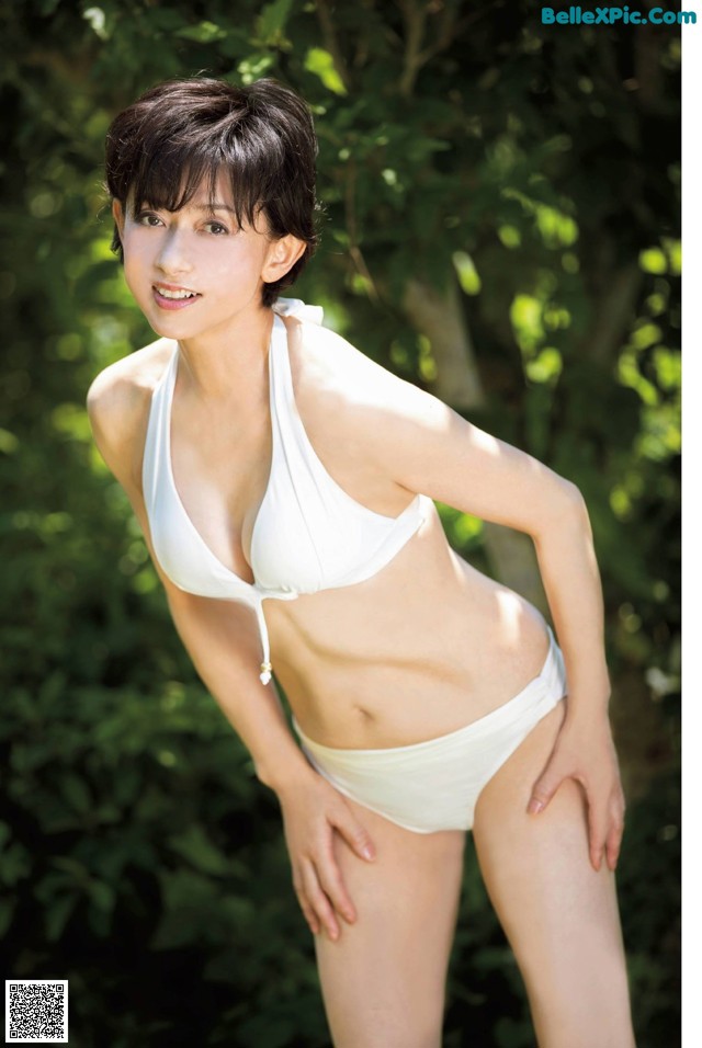 A woman in a white bikini posing for a picture.