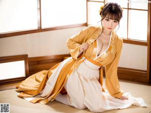 A woman in a purple kimono posing for a picture.