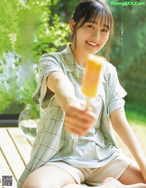 A woman in a white shirt is smiling and posing for a magazine.