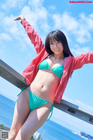 A woman in a white bikini standing on a beach.