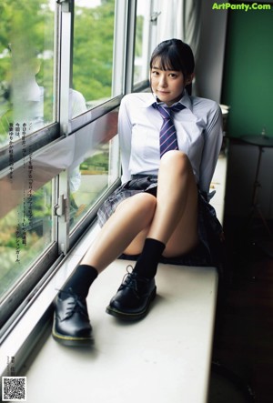 A woman in a school uniform holding an umbrella and a guitar.