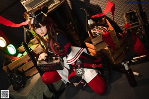 A woman sitting on the ground holding a boombox.