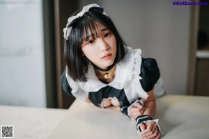 A woman in a white shirt and black skirt sitting on a couch.