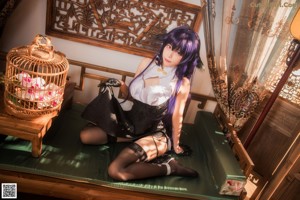 A woman with long purple hair sitting on a table.