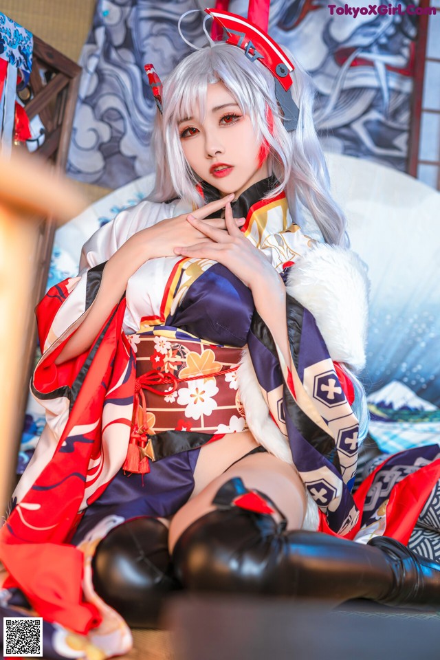 A woman in a kimono sitting on a bed.