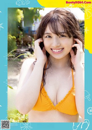 A woman in a yellow bikini standing in the ocean.