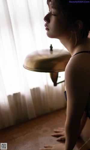 A woman in a black lingerie laying on a table.